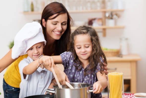 Mom cooking pasta with kids