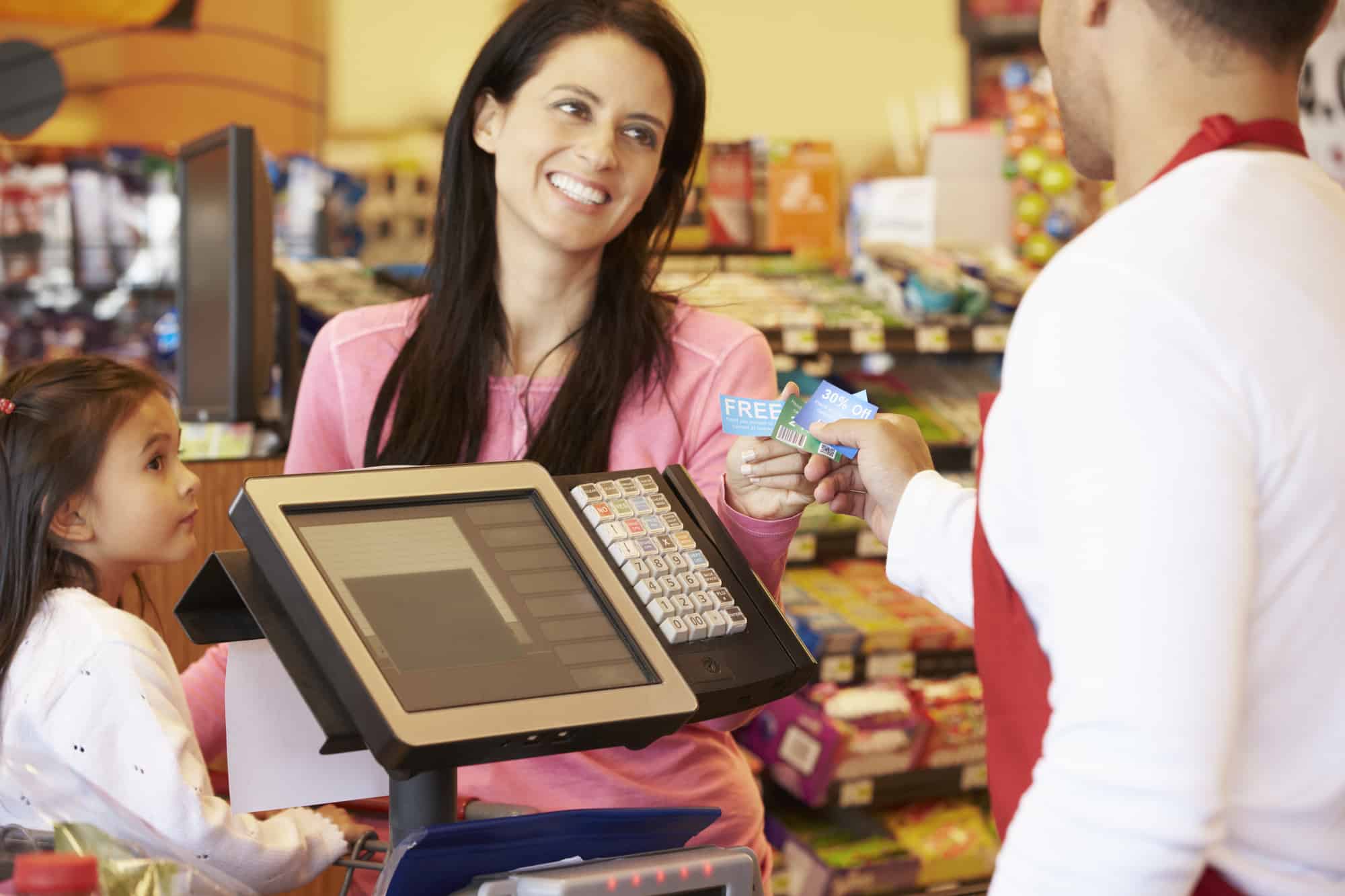 Mother Paying For Family Shopping At Checkout With Card