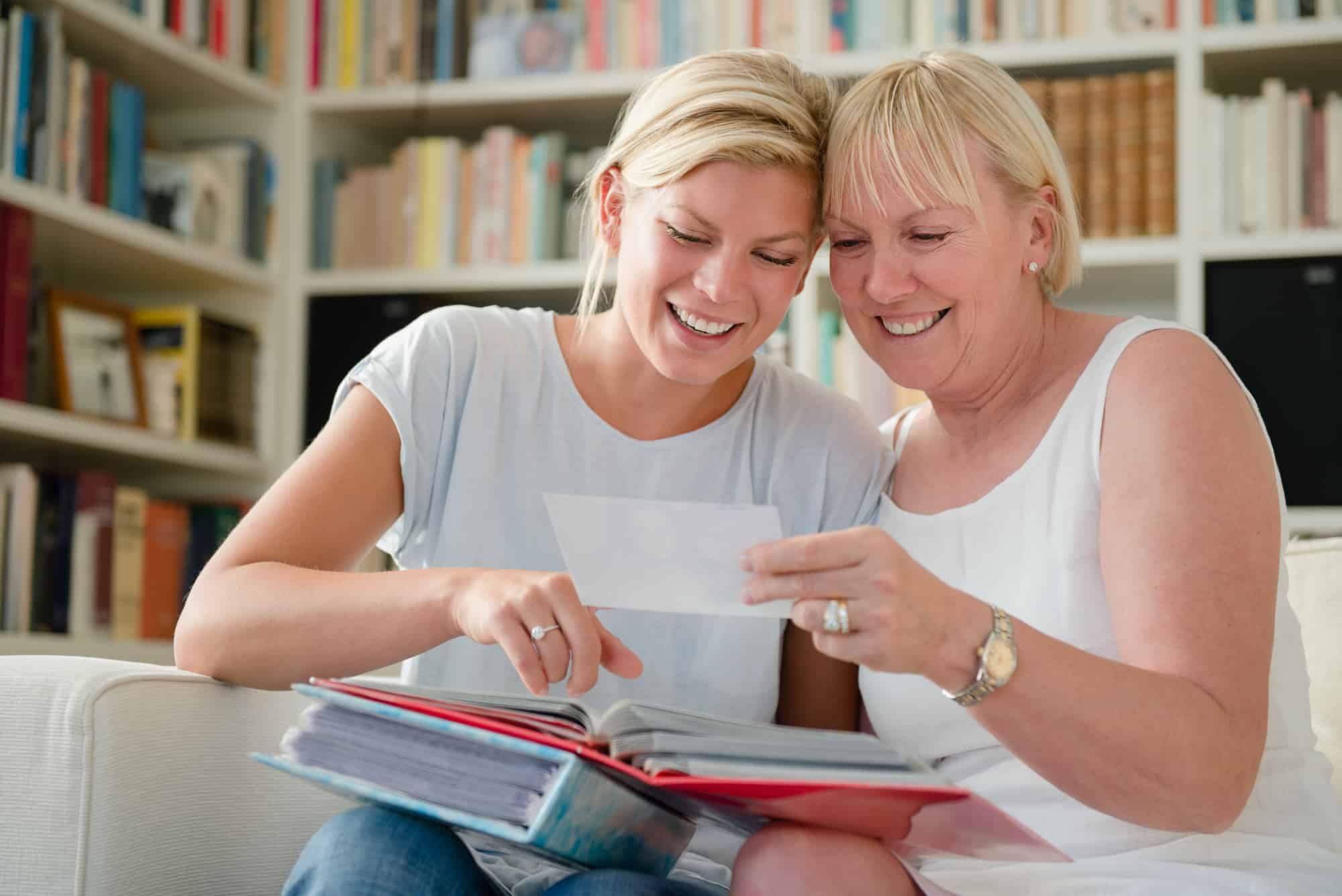 Mother and daughter looking at pictures in photo album