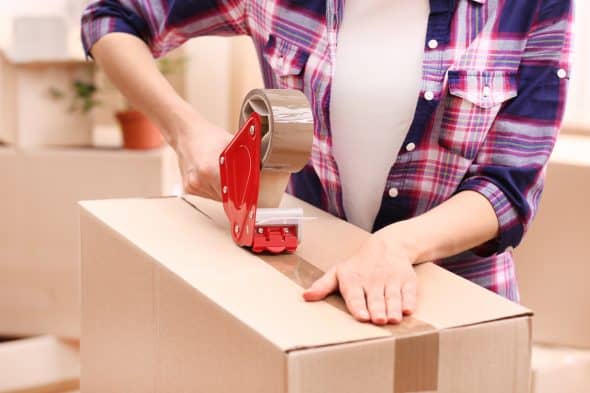 Woman packing boxes with tape