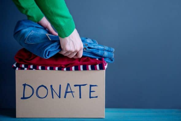 Donation Concept - Woman Preparing her Used Old Clothes into a Donate Box