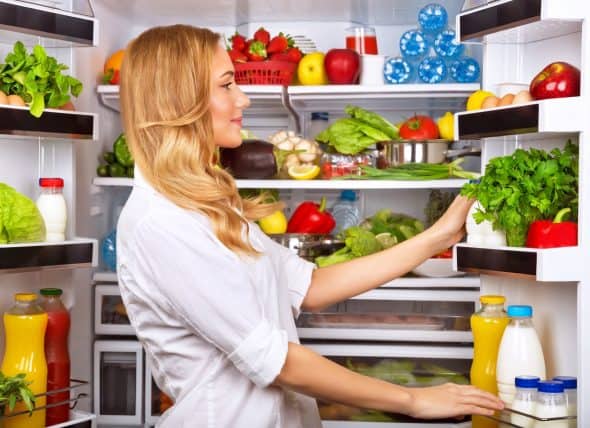 woman-looking-into-refrigerator-full-of-produce