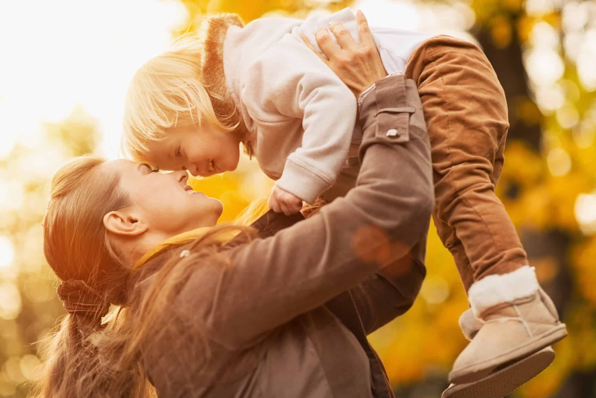 Young woman lifting child up