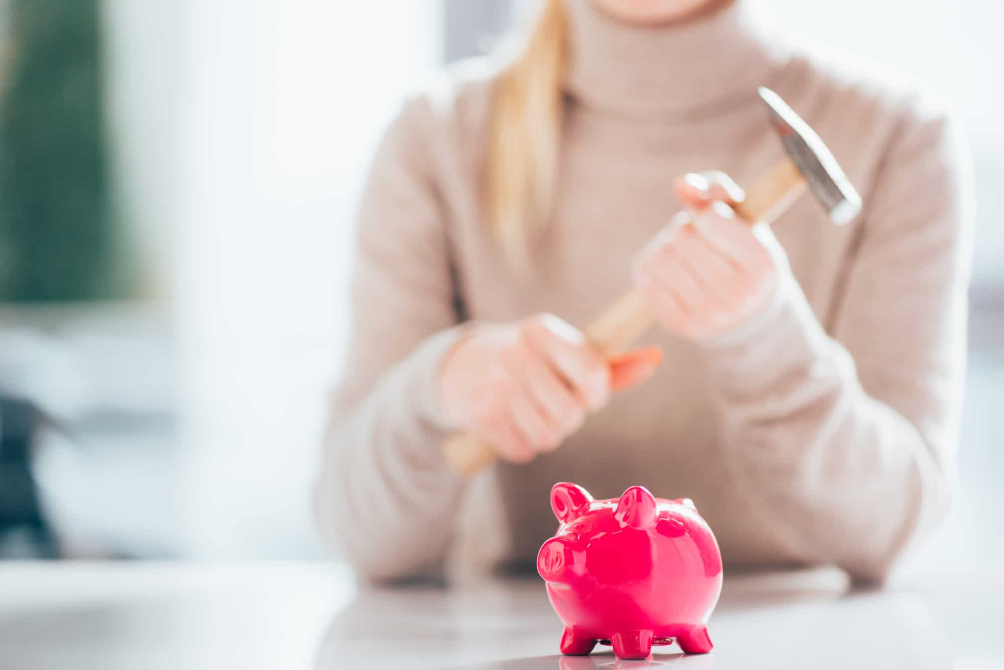 Woman with piggy bank and hammer
