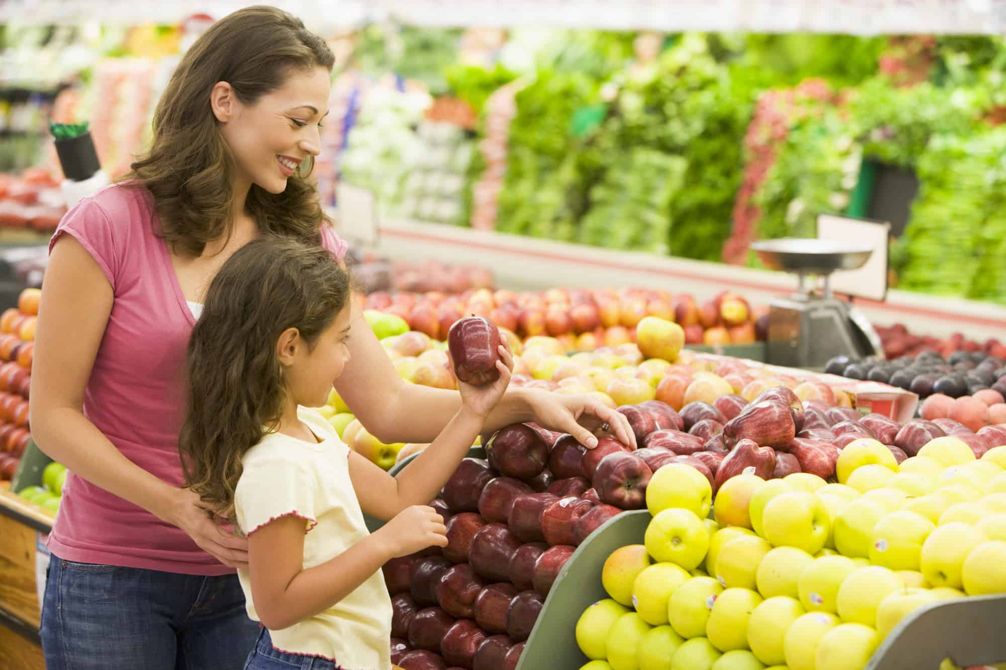 Mother and daughter shopping for fresh produce in supermarket