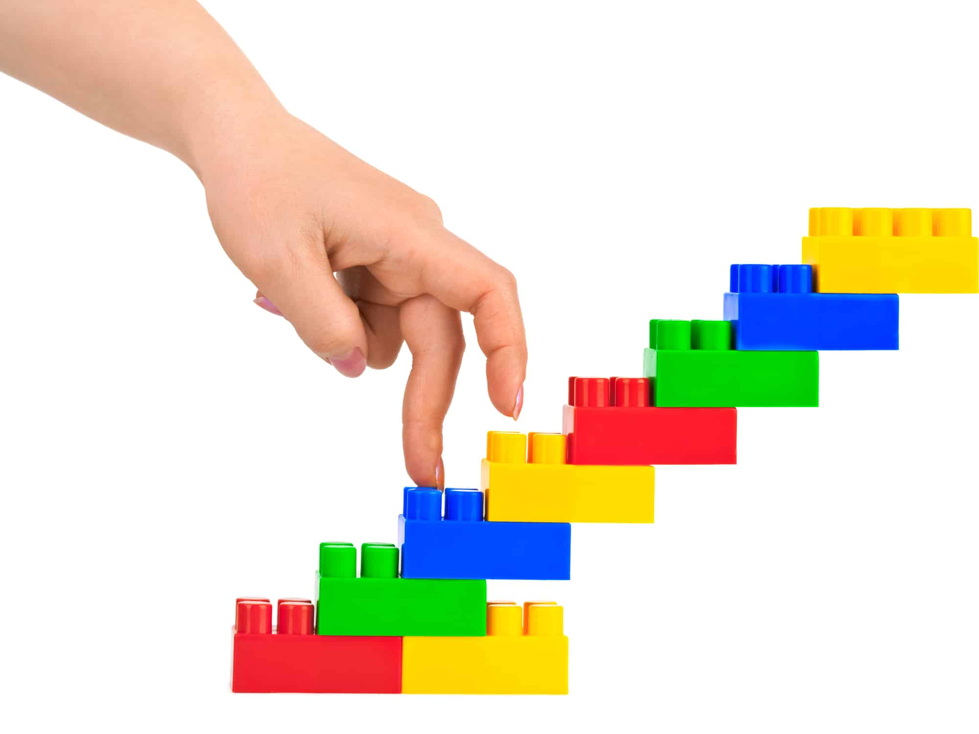 Hand walking up toy stairs made of building blocks