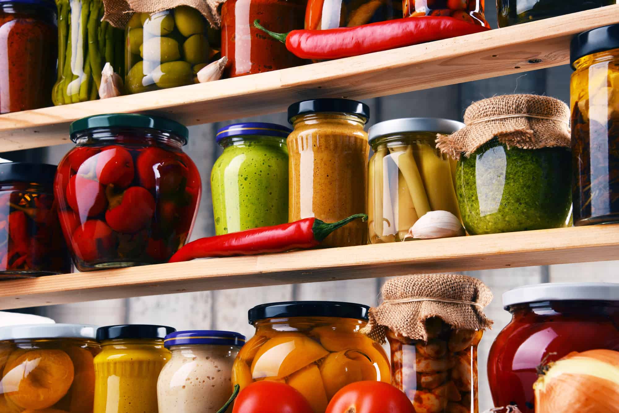 jars with variety of pickled vegetables in pantry