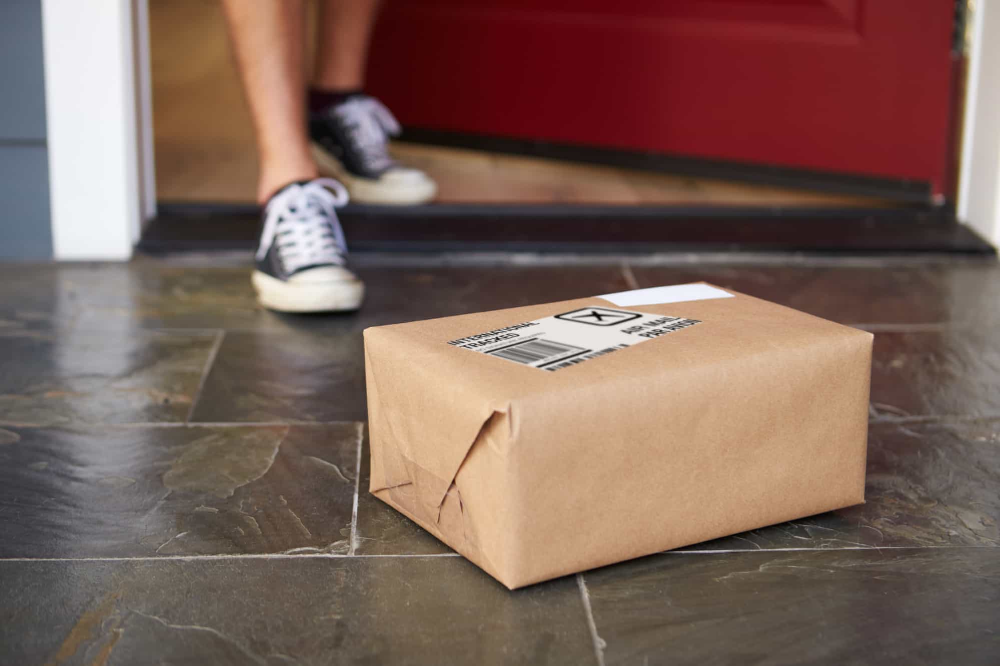 man picking up a package from front porch