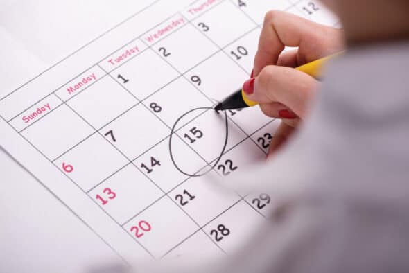 Woman circling date on calendar